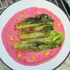 a plate of Braised Pak Choi with Ginger & Pink Tahini Cream